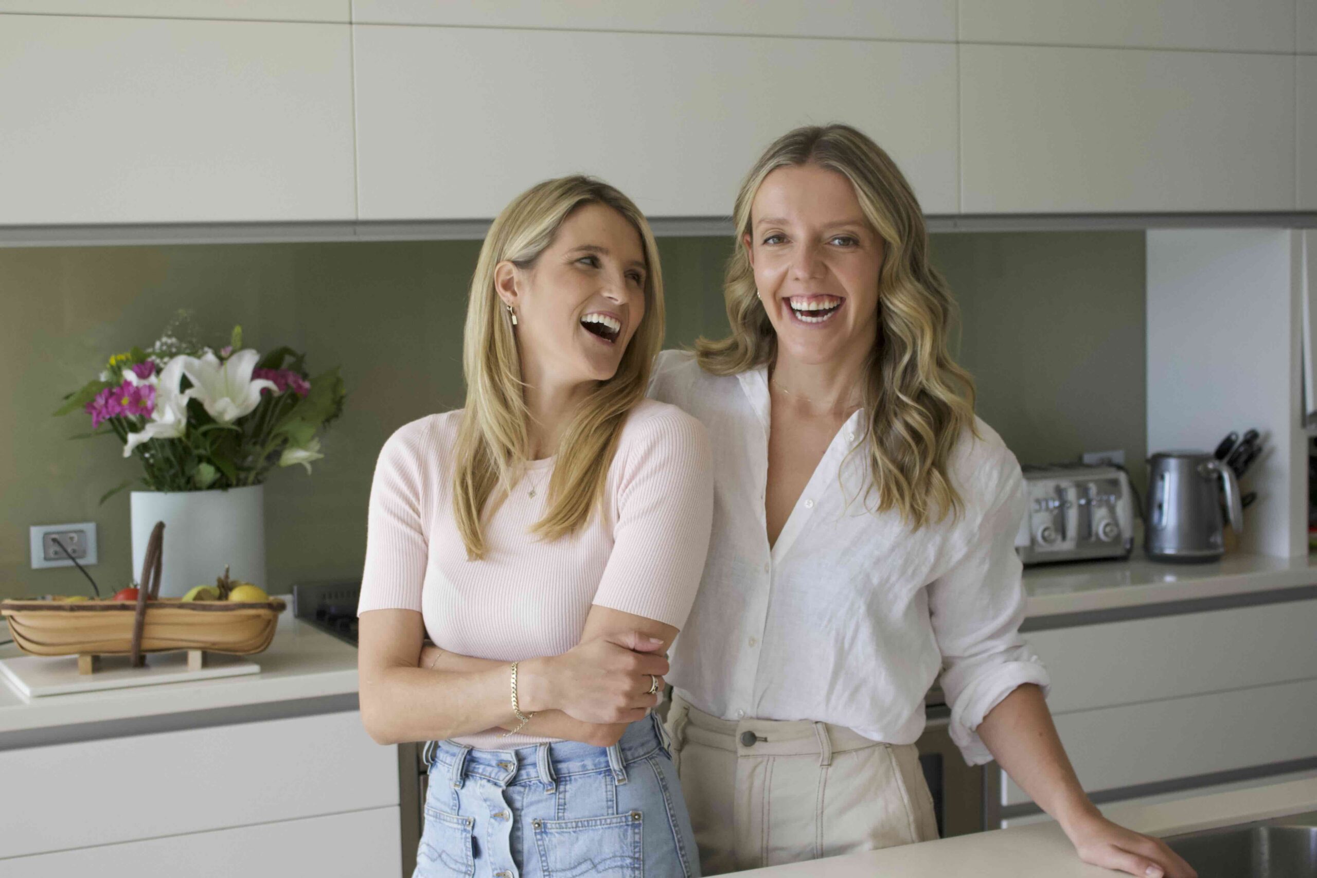 Anna and Alex, Accredited Practising Dietitians, laughing together in a kitchen